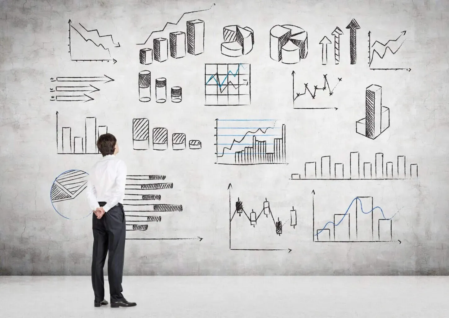 Man analyzing various hand-drawn business graphs.