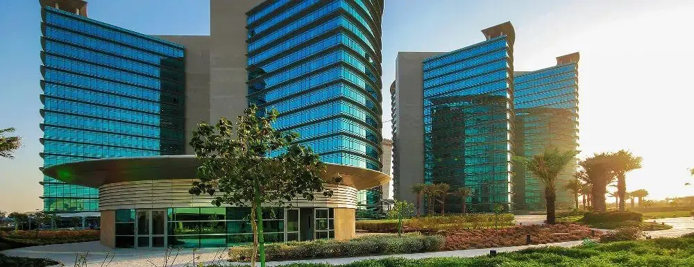 Modern glass office buildings with green landscaping.