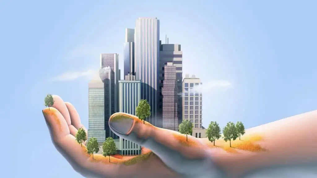 Hand die een miniatuurstadsgezicht en bomen vasthoudt.