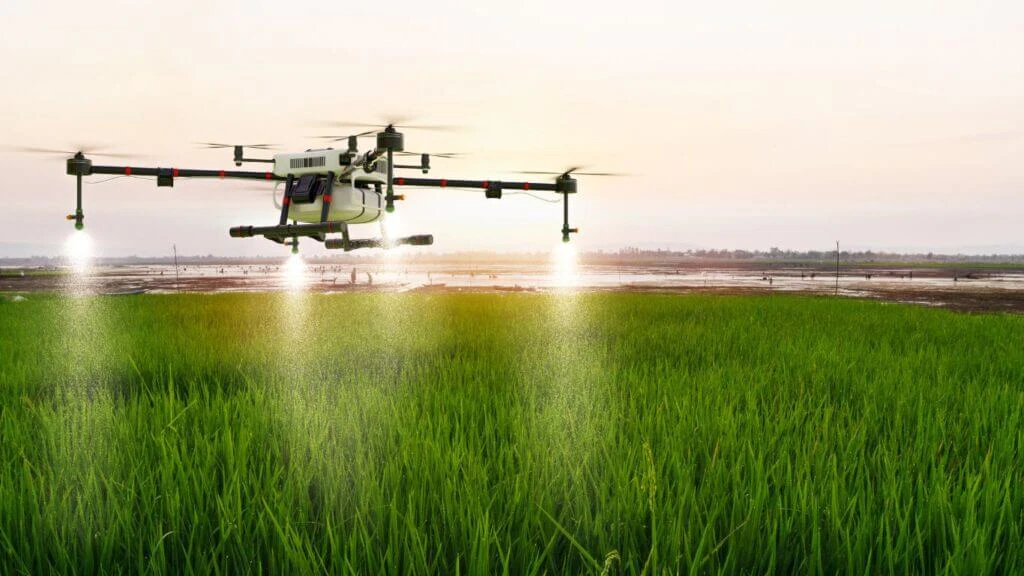 Un drone pulvérise des pesticides sur un champ de culture verte