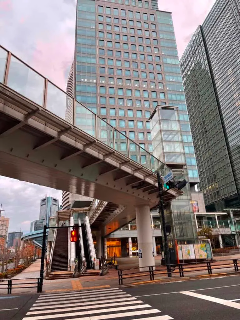 Urban skyscrapers with pedestrian bridge and crosswalk.