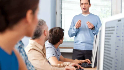 Uomo che fa una presentazione ai colleghi al computer.